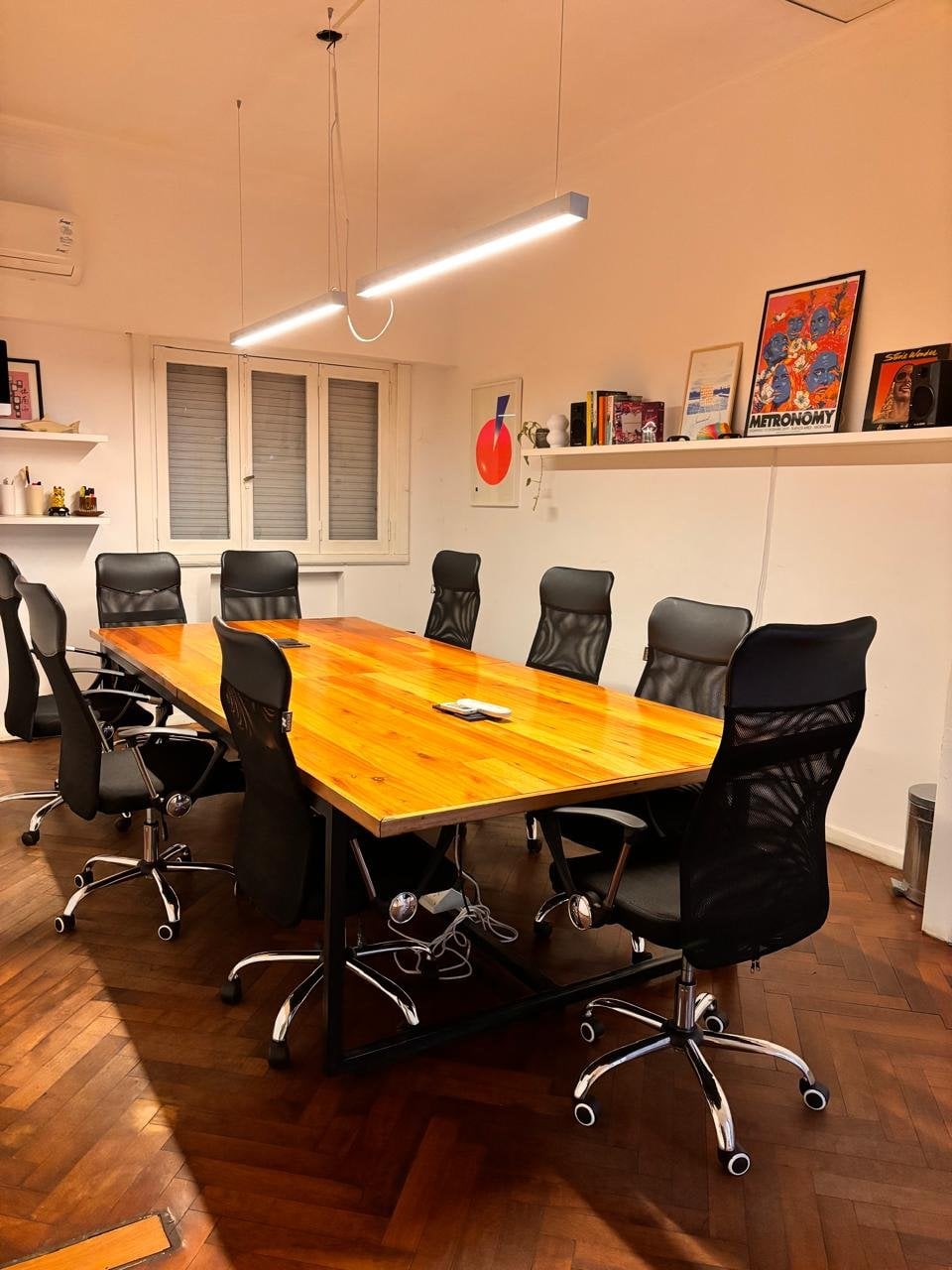 Oficina privada Pulmón en Pawer Belgrano: mesa para 8 personas, sillas ergonómicas y biblioteca con posters, espacio interno silencioso